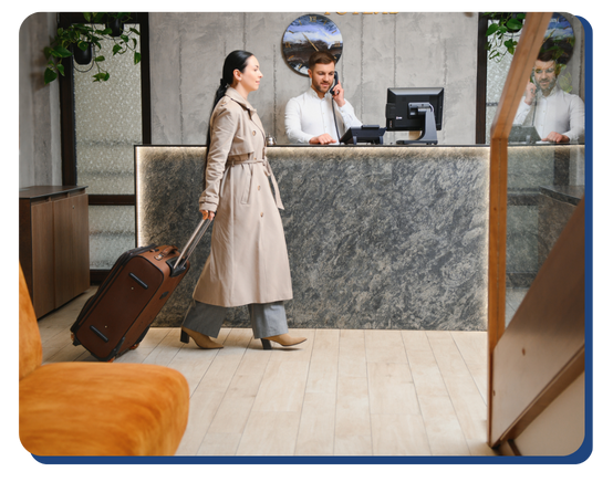 Female guest arriving at a clean and modern hotel reception area, with front desk staff ready to assist, reflecting high hospitality and sanitation standards.
