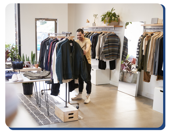 A casual retail clothing store with neatly organized apparel and a gleaming polished floor, showing the effectiveness of regular retail cleaning services.