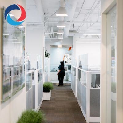 Modern office hallway being cleaned by a professional from a commercial cleaning company in Burlington, ensuring a spotless and well-maintained workspace.