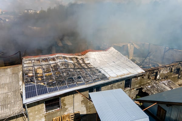 building on fire with collapsed walls