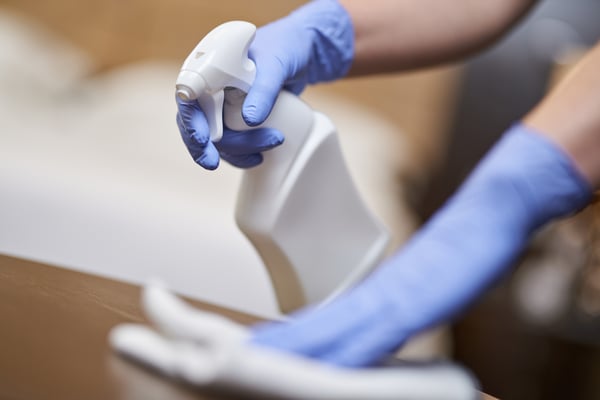maid-disinfecting-bedside-table-in-the-bedroom-2023-11-27-05-15-15-utc