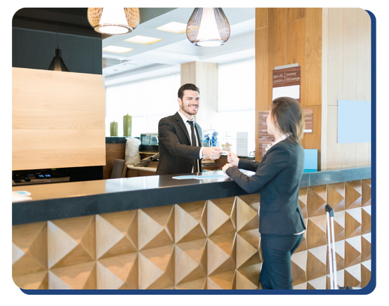 Hotel receptionist handing keycard to guest at a modern and clean front desk, illustrating professional and welcoming check-in service.