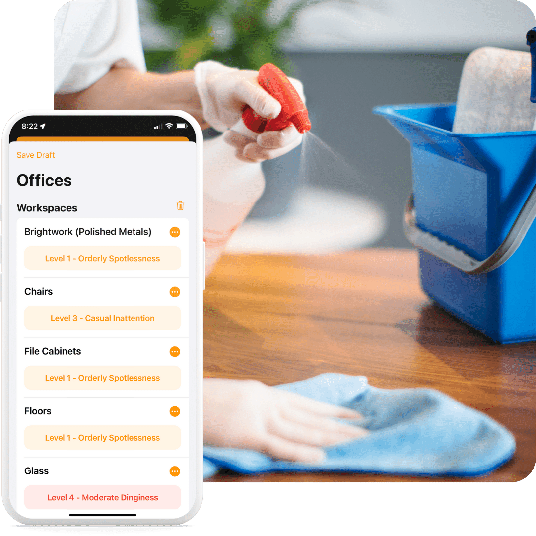 A person cleans a wooden surface with a cloth while spraying cleaner. In the foreground, a smartphone displays a cleaning checklist app with cleanliness levels for various office workspace areas.